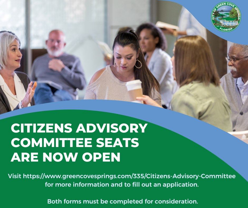 A group sitting at a table in a meeting reading notes with words 