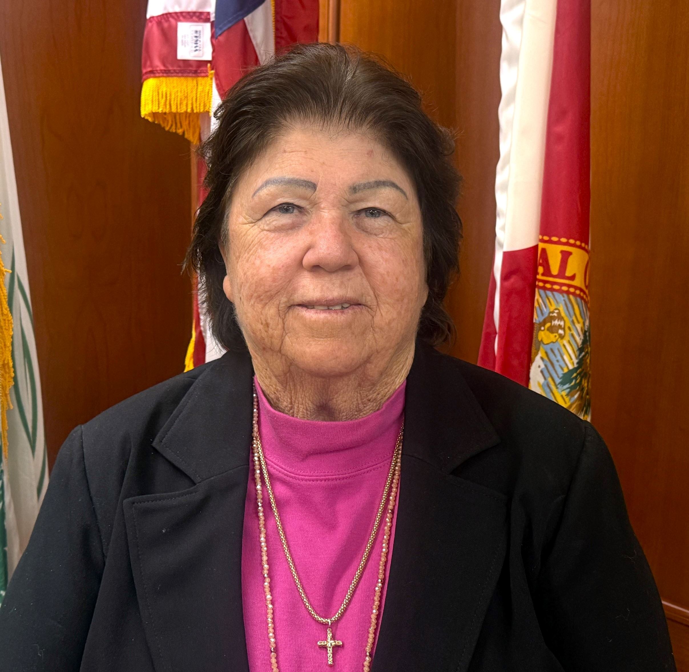 Council Member Glee Glisson standing in front of American Flag in Council Chambers.